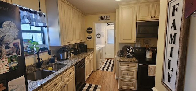 kitchen featuring sink, dark stone counters, independent washer and dryer, and black appliances