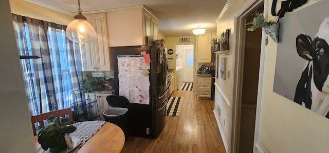 kitchen with pendant lighting, cream cabinets, ornamental molding, and light wood-type flooring