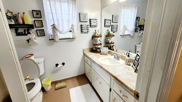 bathroom with tile patterned floors, toilet, vanity, and baseboards