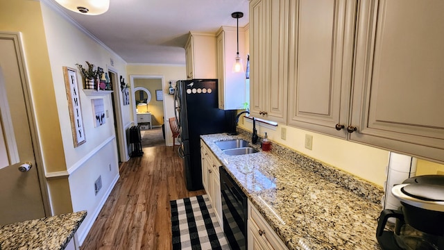 kitchen featuring a sink, cream cabinets, crown molding, and freestanding refrigerator