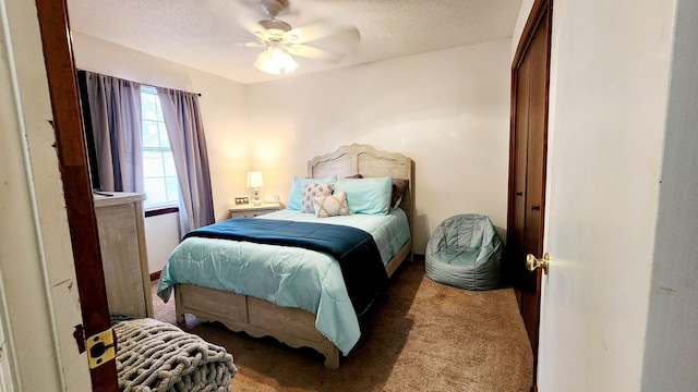 bedroom with a ceiling fan, a textured ceiling, and carpet flooring