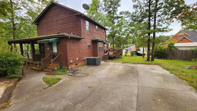 view of home's exterior with a wooden deck, central air condition unit, and a lawn