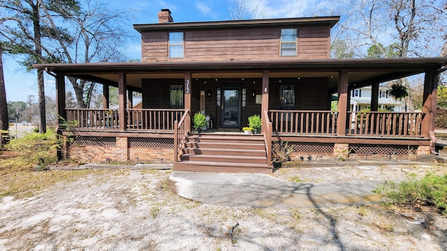 country-style home featuring a porch and a chimney