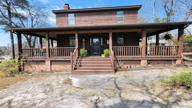 farmhouse-style home with covered porch and a chimney