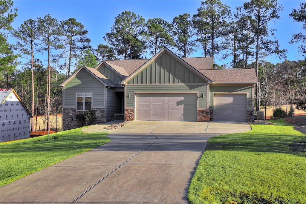 craftsman-style house with a garage, central air condition unit, and a front yard