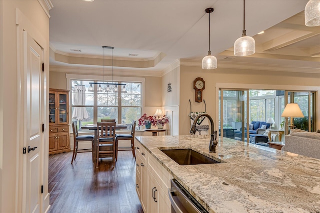 kitchen with a sink, ornamental molding, a raised ceiling, white cabinetry, and dark wood-type flooring