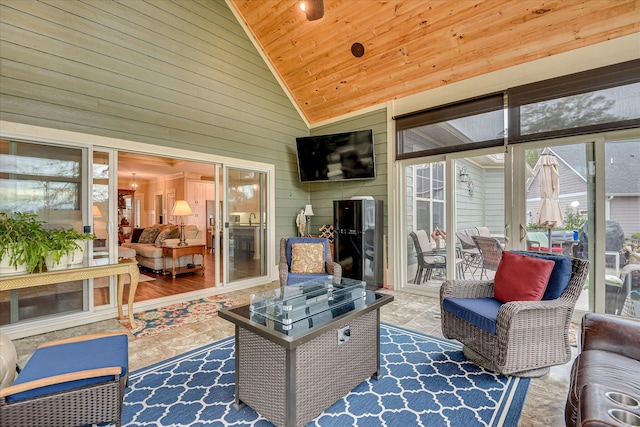 sunroom / solarium with high vaulted ceiling, a wealth of natural light, wood ceiling, and wooden walls