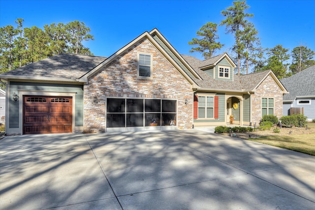 craftsman-style home featuring stone siding, driveway, and roof with shingles