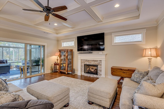 living room with coffered ceiling, wood finished floors, ornamental molding, a fireplace, and ceiling fan
