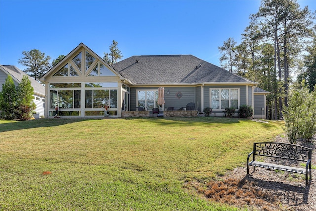 back of house with a lawn, a sunroom, and a shingled roof