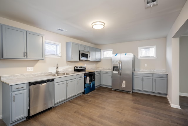 kitchen with visible vents, plenty of natural light, gray cabinets, a sink, and appliances with stainless steel finishes