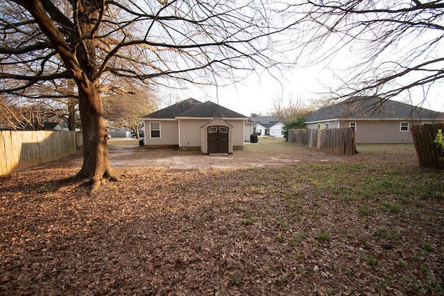 view of yard with a shed, an outdoor structure, and fence