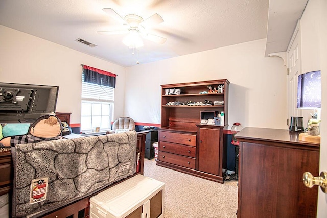 bedroom with ceiling fan, visible vents, and light colored carpet