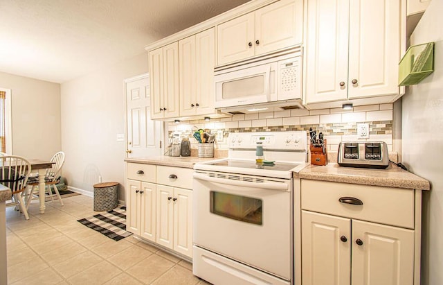 kitchen with tasteful backsplash, white appliances, and light countertops