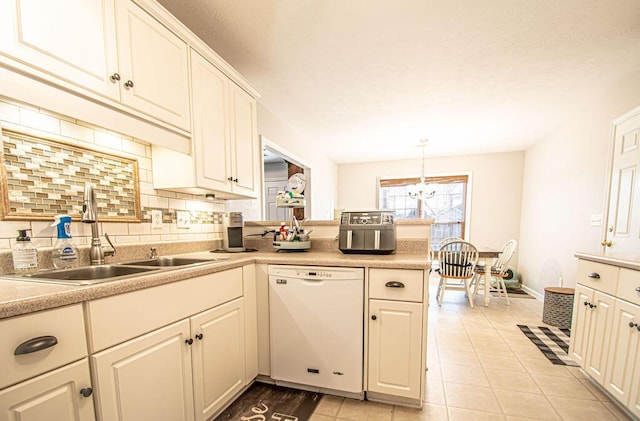 kitchen with dishwasher, backsplash, light countertops, a sink, and light tile patterned flooring