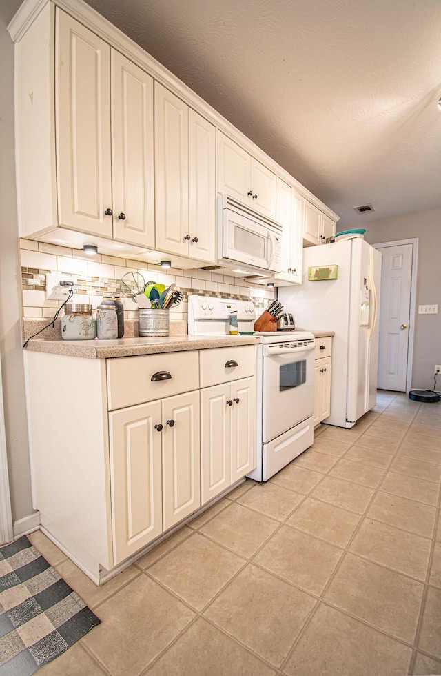 kitchen featuring light tile patterned floors, white appliances, visible vents, light countertops, and decorative backsplash