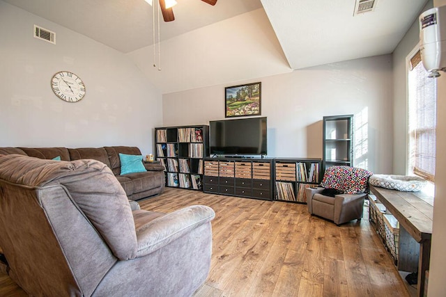 living room with wood-type flooring, visible vents, vaulted ceiling, and a ceiling fan