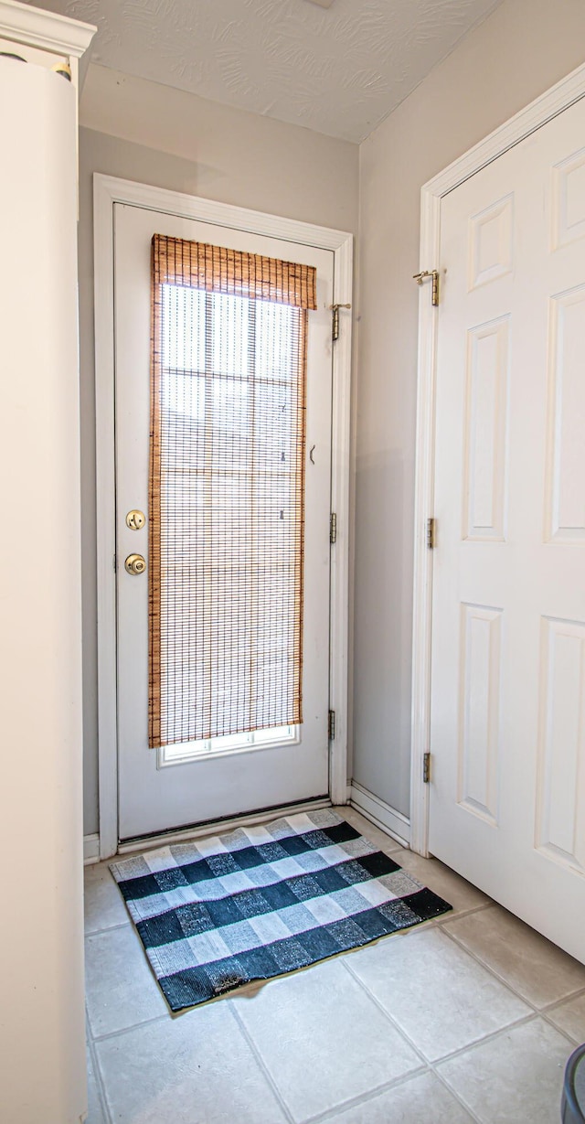 entryway with tile patterned flooring and a textured ceiling