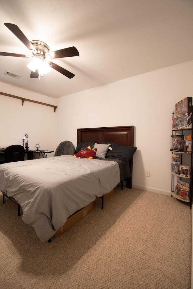 carpeted bedroom featuring a ceiling fan, visible vents, and baseboards