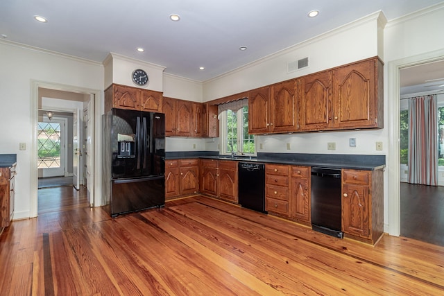 506 Regent Pl, Augusta, GA 30909 - kitchen featuring black appliances, light wood-style floors, brown cabinetry, dark countertops, and crown molding