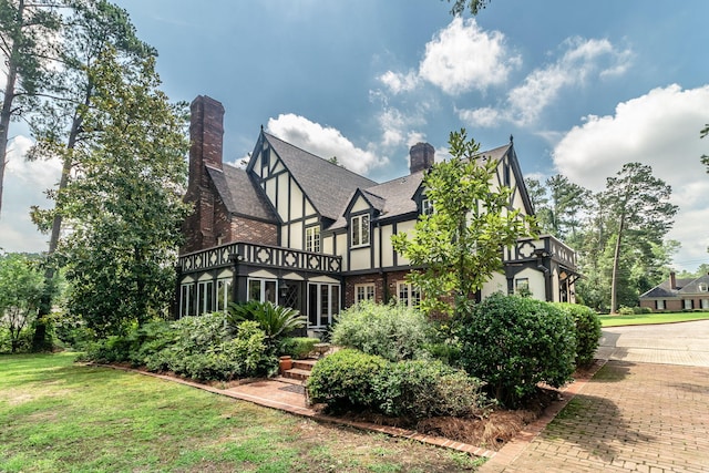 506 Regent Pl, Augusta, GA 30909 - back of house featuring a balcony, a chimney, stucco siding, and a yard