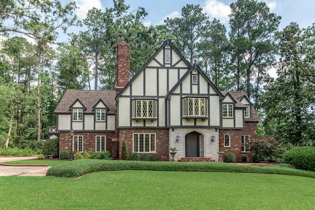 506 Regent Pl, Augusta, GA 30909 - tudor house featuring a front lawn, stucco siding, a chimney, and brick siding