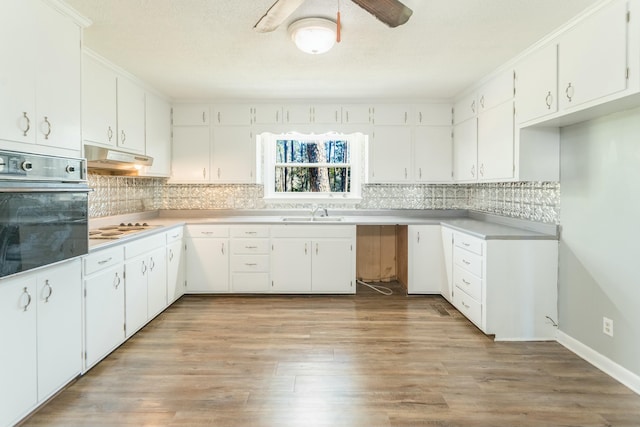 kitchen featuring black oven, white gas cooktop, sink, and white cabinets