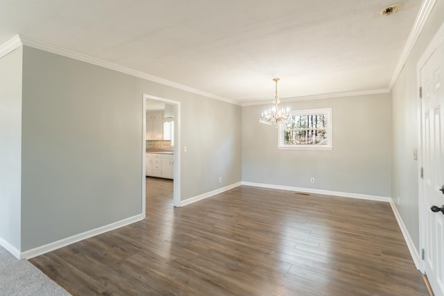 empty room with a notable chandelier, dark hardwood / wood-style floors, and crown molding