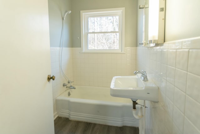 bathroom featuring sink, hardwood / wood-style floors, and tub / shower combination
