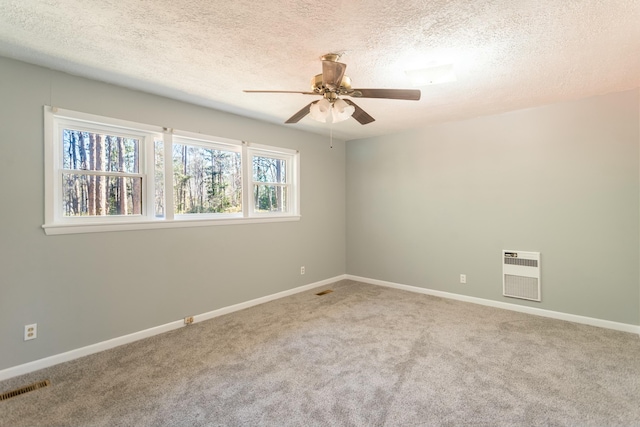 empty room featuring carpet flooring, plenty of natural light, a textured ceiling, and heating unit