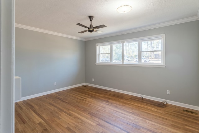 spare room with a textured ceiling, hardwood / wood-style flooring, ceiling fan, and crown molding