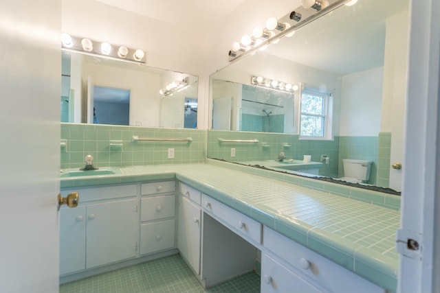 bathroom with tile patterned floors, vanity, toilet, and tasteful backsplash