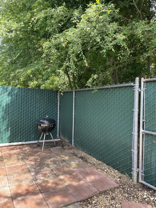 view of patio featuring a grill and fence
