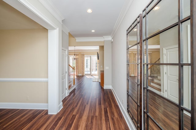 hallway featuring dark hardwood / wood-style flooring, crown molding, and an inviting chandelier