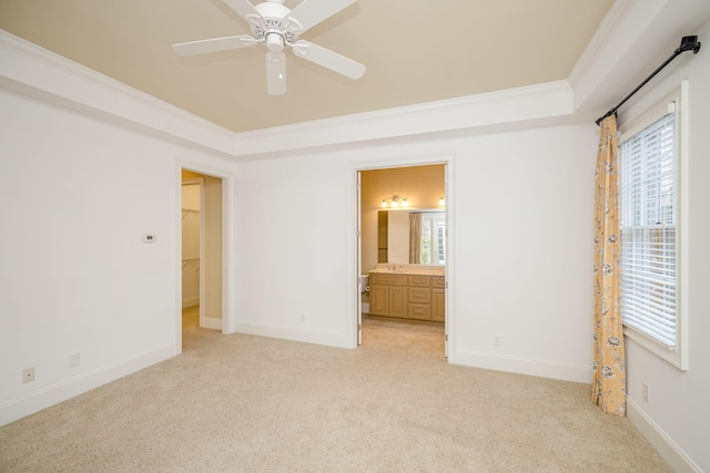 unfurnished bedroom featuring connected bathroom, ceiling fan, crown molding, and light carpet