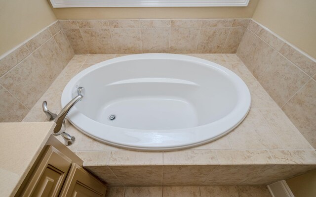 bathroom with vanity and tiled bath