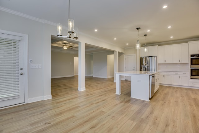 kitchen featuring white cabinetry, stainless steel appliances, and ornamental molding