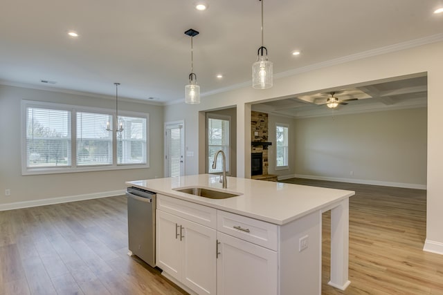 kitchen featuring open floor plan, dishwasher, a wealth of natural light, a fireplace, and a sink