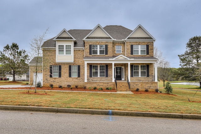 craftsman-style home featuring a porch, a garage, brick siding, and a front lawn