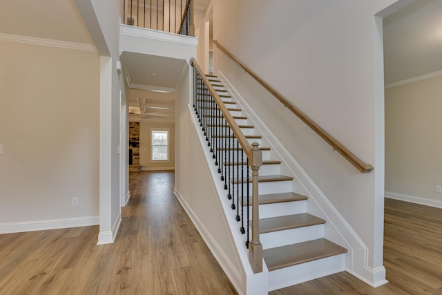 stairway featuring crown molding, baseboards, and wood finished floors