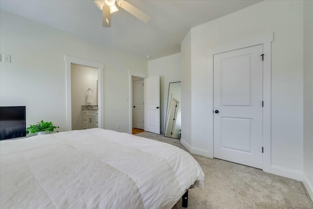 bedroom with light carpet, ensuite bath, baseboards, and a ceiling fan