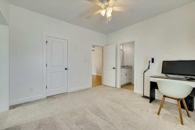 office area with a ceiling fan, light colored carpet, and baseboards