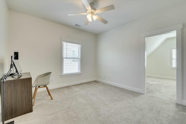 office space with plenty of natural light, baseboards, and light colored carpet