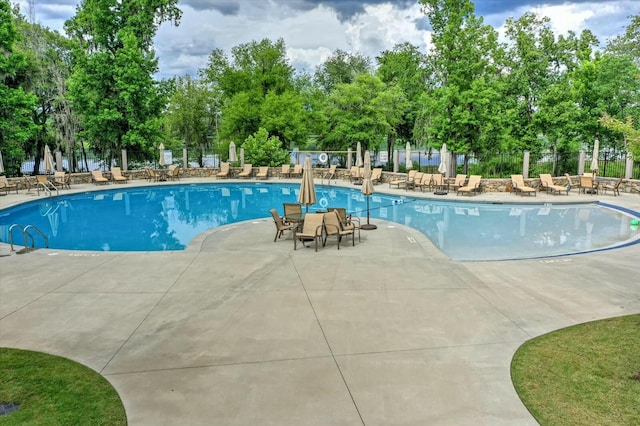 community pool featuring a patio and fence