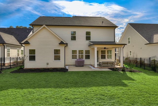 back of property with a yard, a fenced backyard, and a ceiling fan