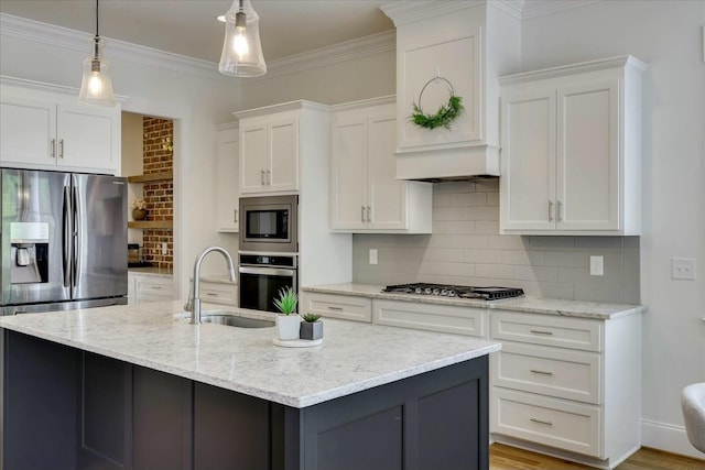 kitchen with a sink, white cabinetry, hanging light fixtures, appliances with stainless steel finishes, and decorative backsplash