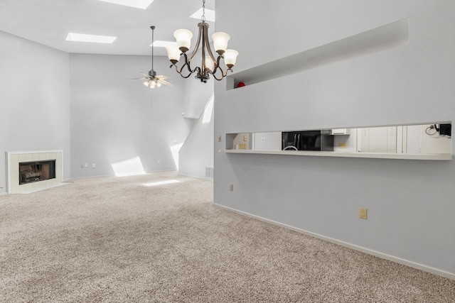 3252 Summerchase Cir, Augusta, GA 30909 - unfurnished living room featuring carpet flooring, high vaulted ceiling, a skylight, ceiling fan, and a fireplace