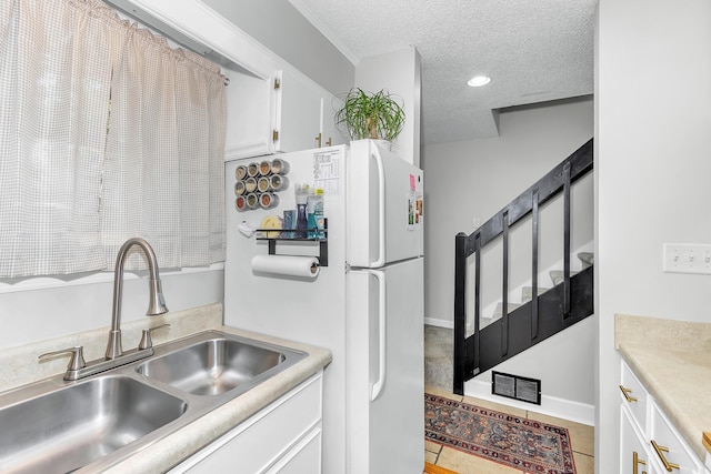 5 Teal Ct, North Augusta, SC 29841 - kitchen featuring a sink, a textured ceiling, white cabinets, light countertops, and freestanding refrigerator