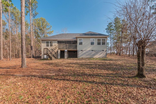 rear view of house featuring stairway, a deck, crawl space, and roof with shingles