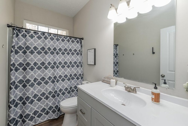 bathroom featuring vanity, curtained shower, and toilet